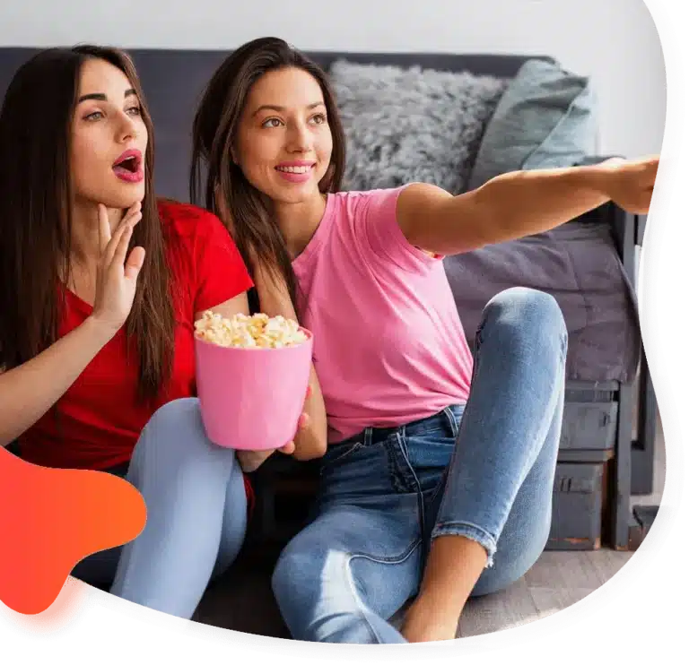 Two friends watching IPTV with popcorn